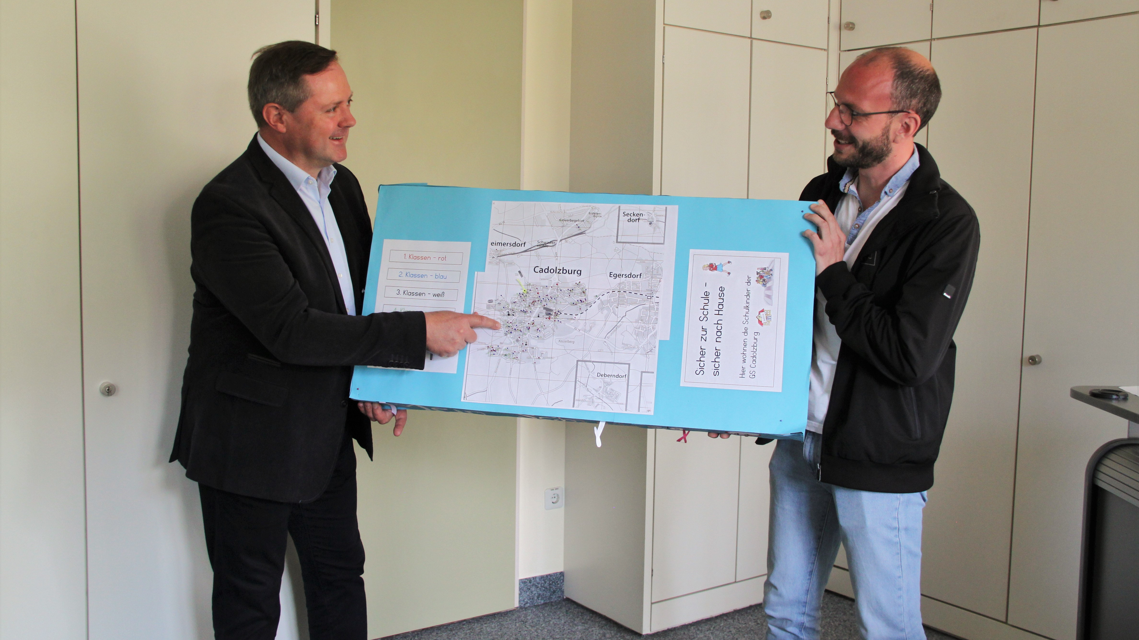 Erster Bürgermeister Bernd Obst übergibt Marktbaumeister Patrick Hankele das Schülerprojekt